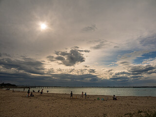 Playing On The Beach Before A Long Pier
