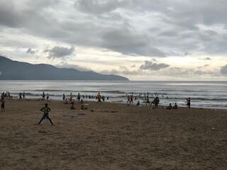 Tropical Beach Activities Beneath Overcast Morning Sky
