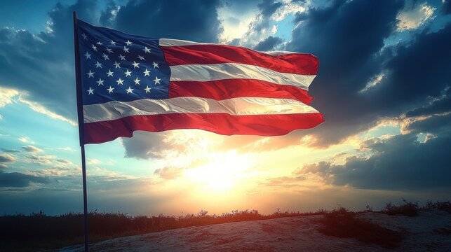 American flag waving on a pole with a dramatic sunset and cloudy sky in the background over a sandy landscape - Powered by Adobe