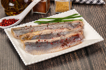 Salted marinated herring fillet with spices
