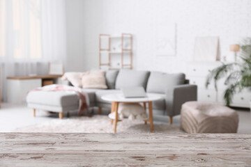 Empty white wooden table against blurred living room interior