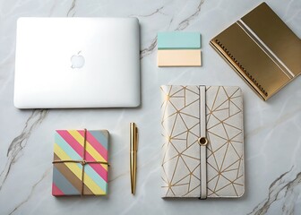 Flat lay of a laptop notebooks pen and gift boxes on a marble surface