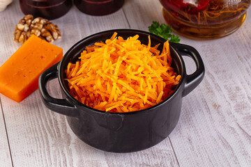 Yellow shredded cheddar cheese in the bowl