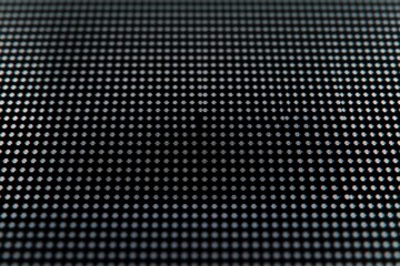 Close-up macro of a digital screen grid showing illuminated pixels in blue and white forming a subtle abstract pattern
