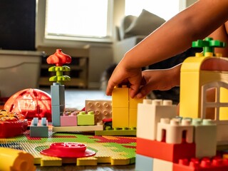 Toddler playing with building blocks toys in the living room