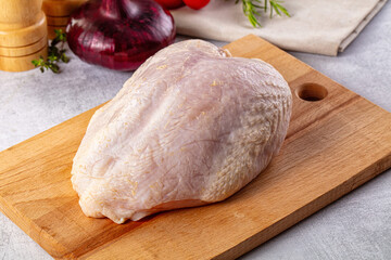 Raw chicken breast with bone and skin
