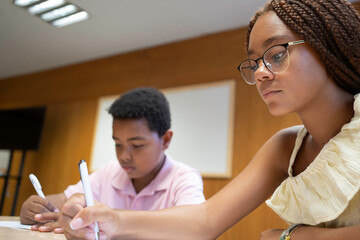 Diverse students concentrating on writing tasks during a school class