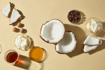 Flat lay with coconut shells, honey, coffee beans and creamy shea butter. Perfect natural background for cosmetic advertising, skincare products, and wellness promotions.