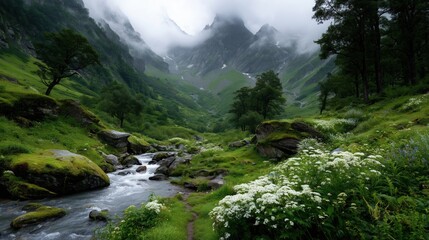 Lush green valley with a winding stream surrounded by foggy mountains and blooming flowers