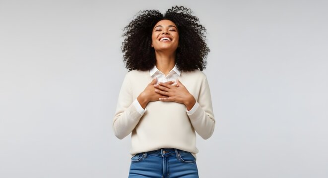 Gratitude and Serenity: A woman of color closes her eyes, hands over her heart, and is in a state of tranquil happiness and contentment. 