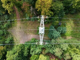 Aerial Drone View of High-Voltage Power Line Tower in Forest Landscape
