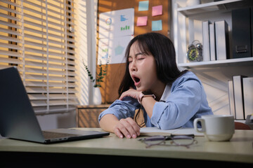 An Asian woman in the office is tired and sleepy.