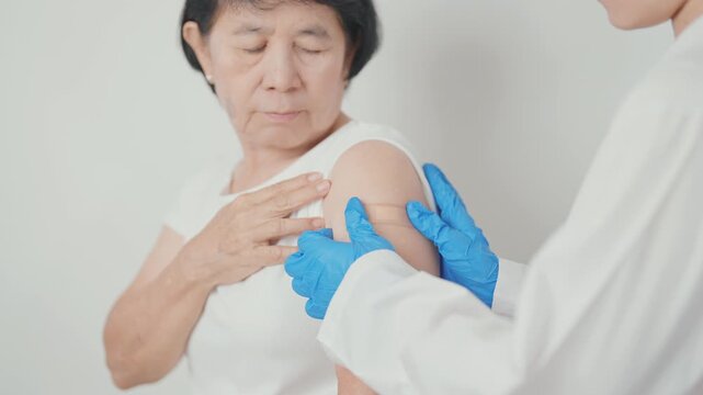 Elderly Woman with bandage after received vaccine. Vaccination and Immunization for Influenza, Herpes Zoster, Tetanus, Covid 19 booster, Dengue, Encephalitis, Rabies, Pneumococcal, IPD, RSV Vaccines