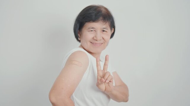 Elderly Woman with bandage after received vaccine. Vaccination and Immunization for Influenza, Herpes Zoster, Tetanus, Covid 19 booster, Dengue, Encephalitis, Rabies, Pneumococcal, IPD, RSV Vaccines