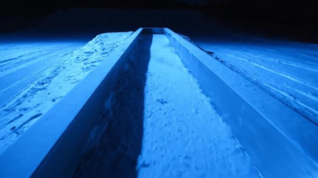 Dramatic Snowboard Slopestyle Rail Feature with Frosted Metal and Blue Floodlight Glow