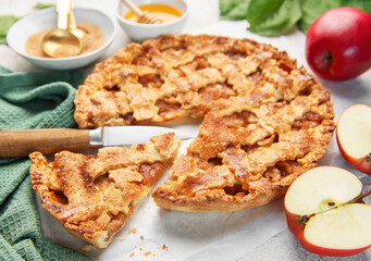 Homemade apple pie with ingredients on concrete background