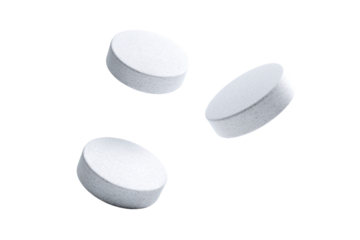 Three white, round pills levitate in a dark background