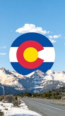 Colorado flag over snowy mountains and road