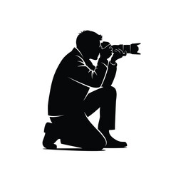 silhouette of a photographer crouching with a camera