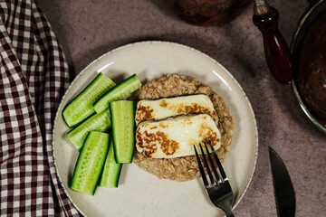 healthy breakfast, porridge oatmeal, fresh green cucumbers, grilled halloumi cheese, simple wellness meal