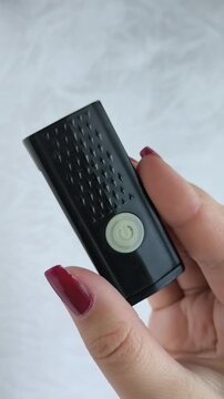 Bicycle flashlight in a woman's hand close-up. A woman turns on and off a bicycle flashlight