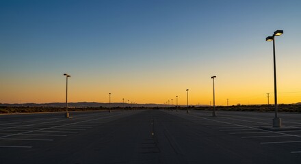 Empty parking lot silhouetted by the sunrise with utility poles open space and a vibrant sky