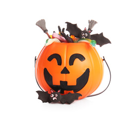 Cauldron in shape of pumpkin with candies for Halloween, brooms and bats isolated on white background, closeup
