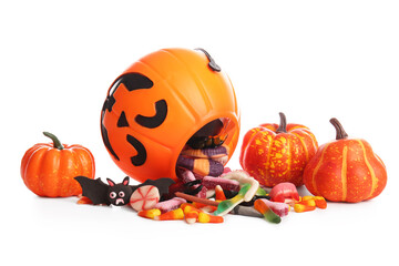 Overturned cauldron with candies for Halloween and pumpkins isolated on white background, closeup