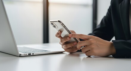 Businesswoman using smartphone and laptop for work