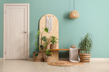 Folding screen, bench and wicker pots with houseplants in interior of living room