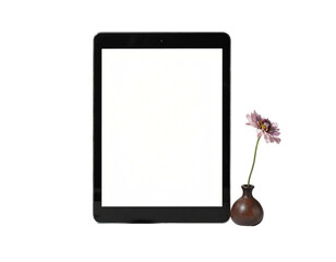 Tablet with white screen and flower in vase against a black background