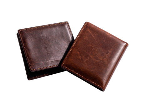 Two brown leather wallets sit on a black surface, capturing soft highlights