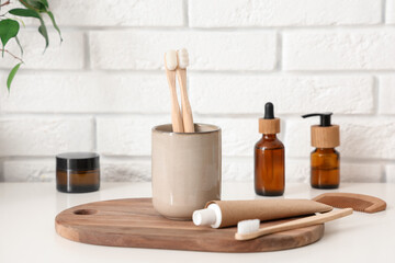Toothpaste and toothbrushes on table in bathroom, closeup