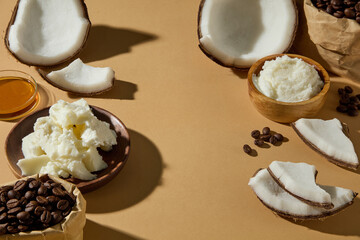 Top view of coconuts, coffee beans, and shea butter cream. Styled naturally to promote hydration and exfoliation in beauty advertising. Copy space