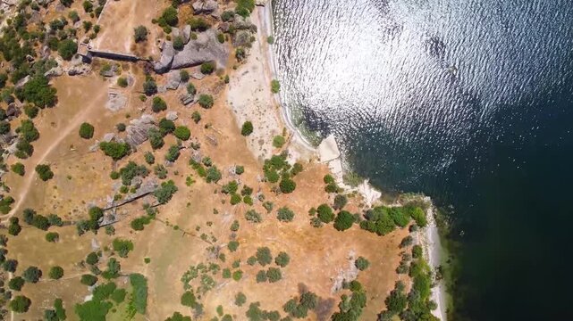 Drone footage captures the stunning aerial perspective of Bafa Lake in Turkey, showcasing its tranquil waters, surrounding natural landscape, and the rugged terrain that borders this unique former Aeg