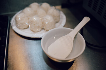 Japanese Rice Balls on Plate with Plastic Rice Paddle and Water Bowl