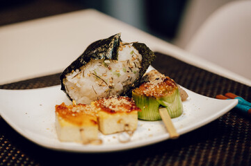 Japanese rice ball and miso dengaku tofu on a white plate — homemade comfort food