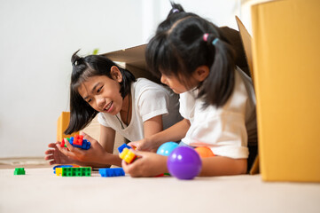 Playful Duo: Two young girls immerse themselves in a world of imaginative play. Surrounded by colorful toys and crafting materials, they build, create, and share moments of laughter and wonder.