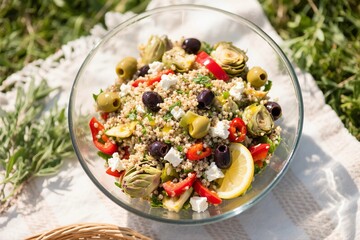 Mediterranean Quinoa Salad with Artichokes and Feta in Glass Bowl Outdoors