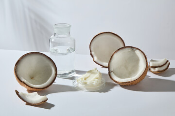 Coconuts and shea butter on white surface. Clear and bright photography perfect for beauty product placement and skincare promotion.