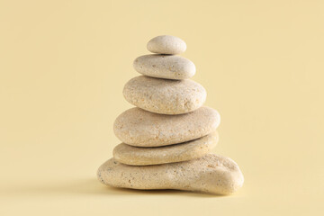 Stack of pebbles on yellow background. Zen concept
