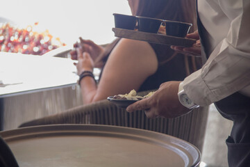 Waiter carefully presenting Mexican cuisine in a close-up moment of professional restaurant service. Concept of hospitality, precision, and quality dining experience.