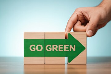 Hand places final wooden block with go green arrow promoting eco-friendly living and sustainability