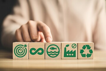 Hand places wooden block with sustainability icon on desk symbolizing circular economy and green initiatives