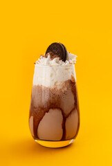 Milkshake with chocolate on a yellow background.