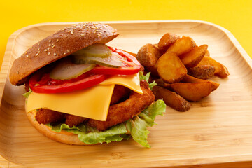 Chicken and cheese sandwich. Cheeseburger on a yellow background.
