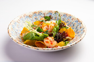 Shrimp salad with orange slices on a plate.