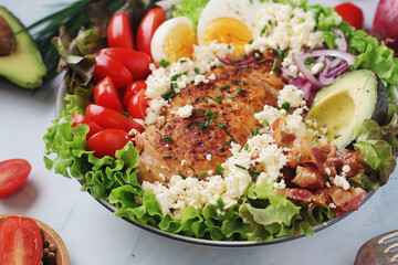 A bowl with cobb salad, traditional American dish