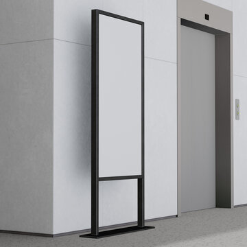 Modern digital signage display stands ready for advertising next to sleek elevator doors in a contemporary office lobby.