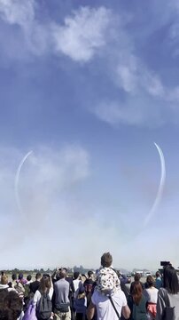 Aerobatic Show Spectacle: A crowd of spectators gazes upward, captivated by the stunning aerobatic maneuvers etched across the sky, creating a spectacle of aerial artistry.